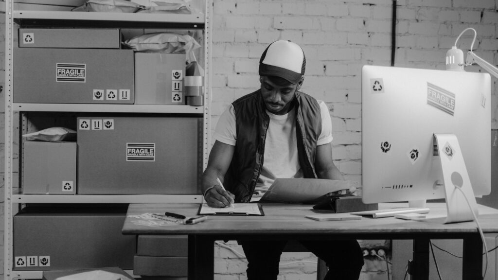 Monochrome Photo of a Business Man writing on a Paper